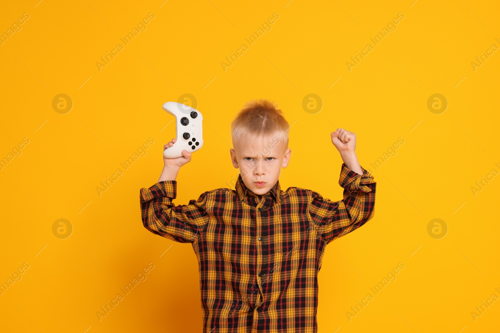 Photo of Little boy with controller on orange background