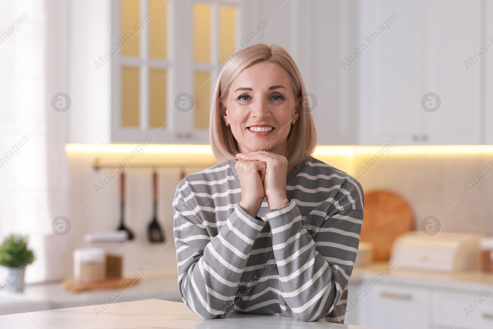 Photo of Portrait of smiling middle aged woman in kitchen