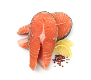 Photo of Fresh raw salmon steaks and spices isolated on white, top view