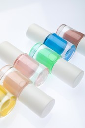 Photo of Nail polishes in bottles on white background, closeup