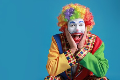 Happy clown on blue background, space for text