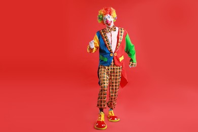 Portrait of happy clown on red background