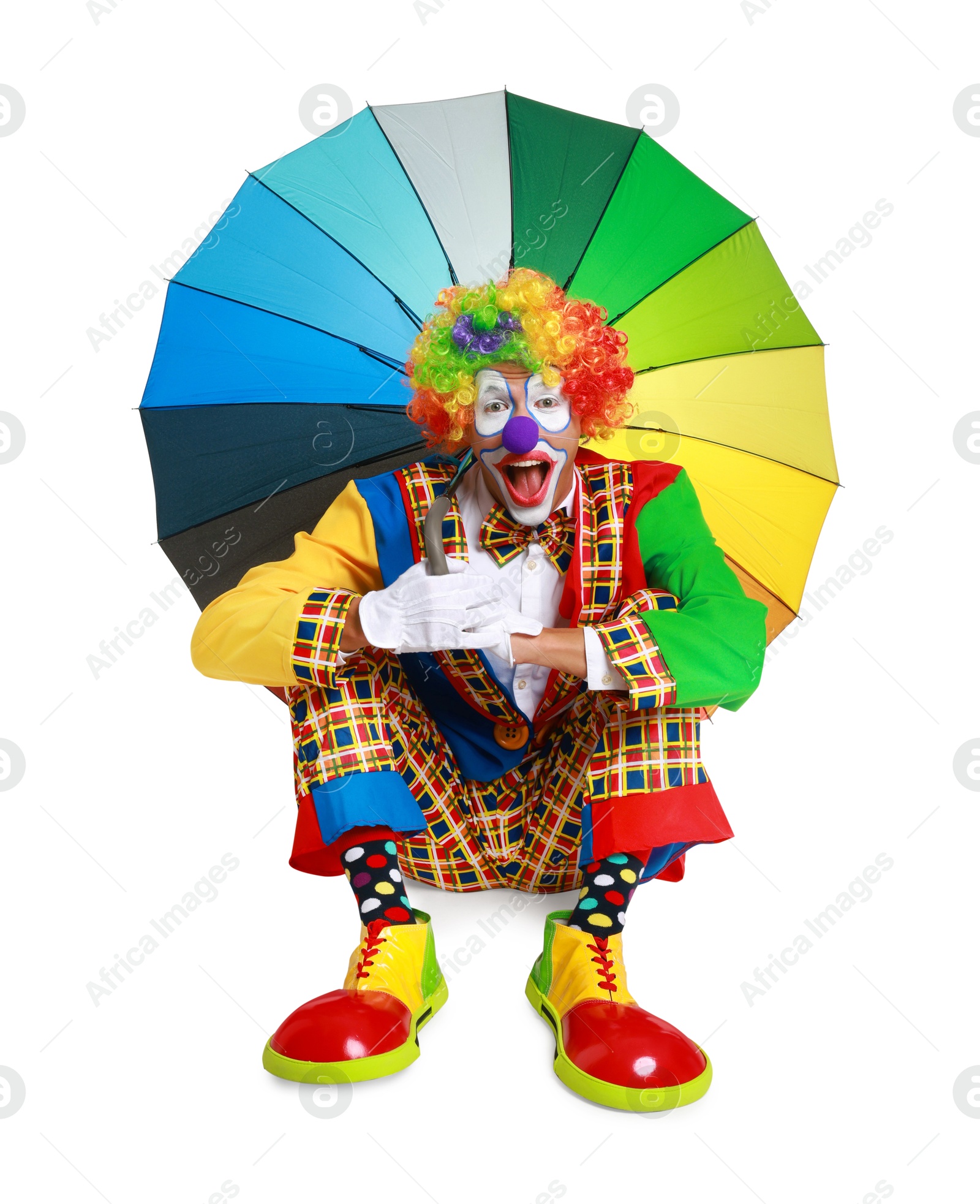 Photo of Emotional clown with colorful umbrella on white background