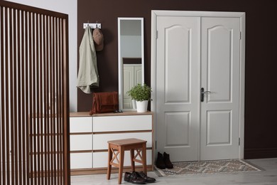 Photo of Stylish hallway interior with coat rack and mirror