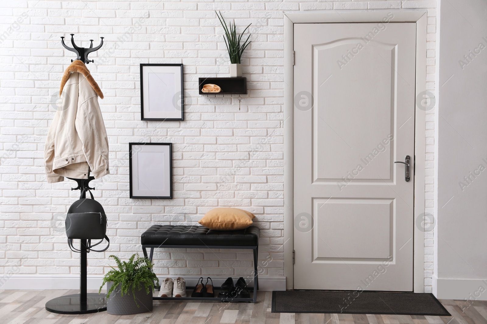 Photo of Stylish hallway interior with coat rack and bench