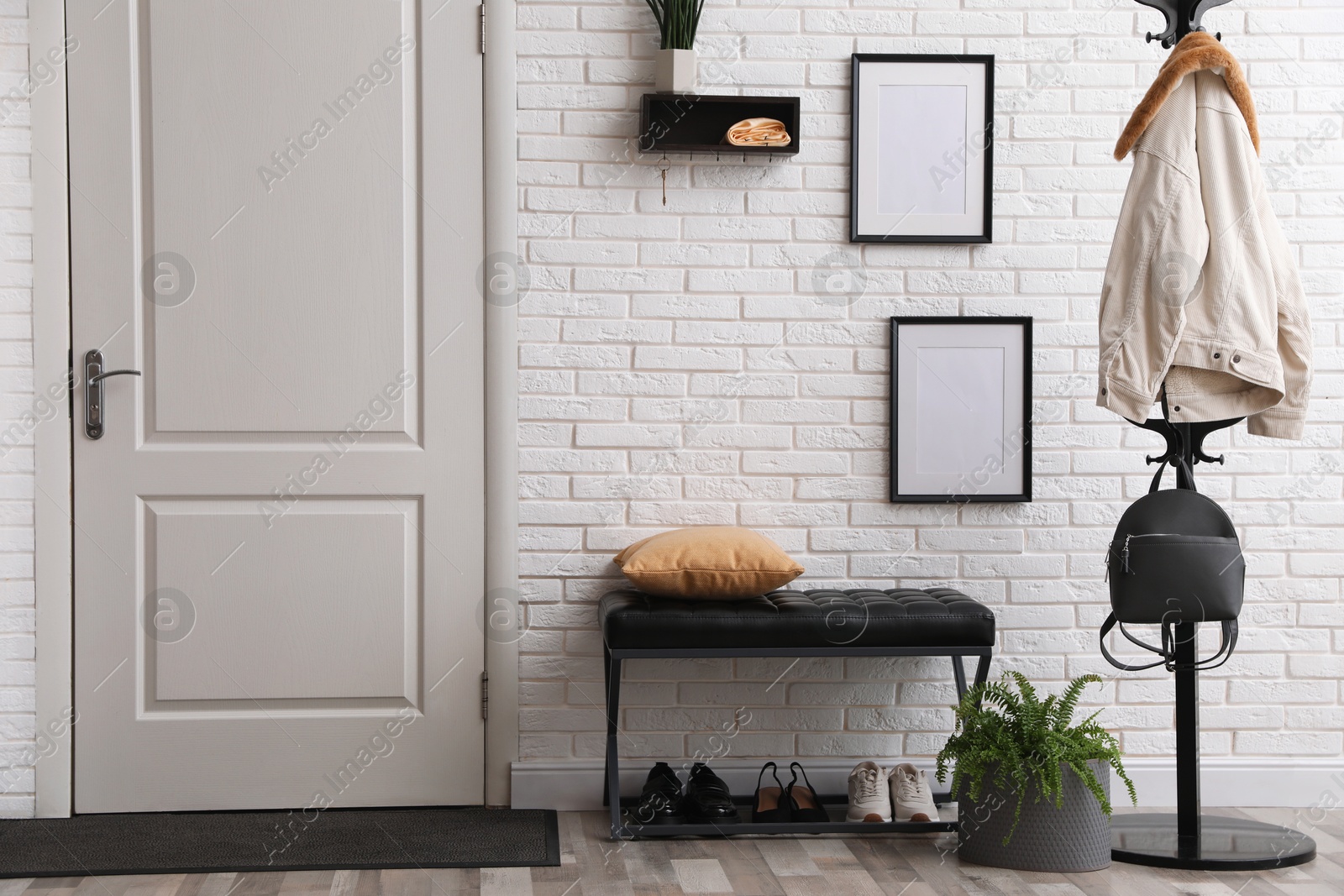 Photo of Stylish hallway interior with coat rack and bench