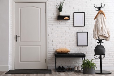 Photo of Stylish hallway interior with coat rack and bench