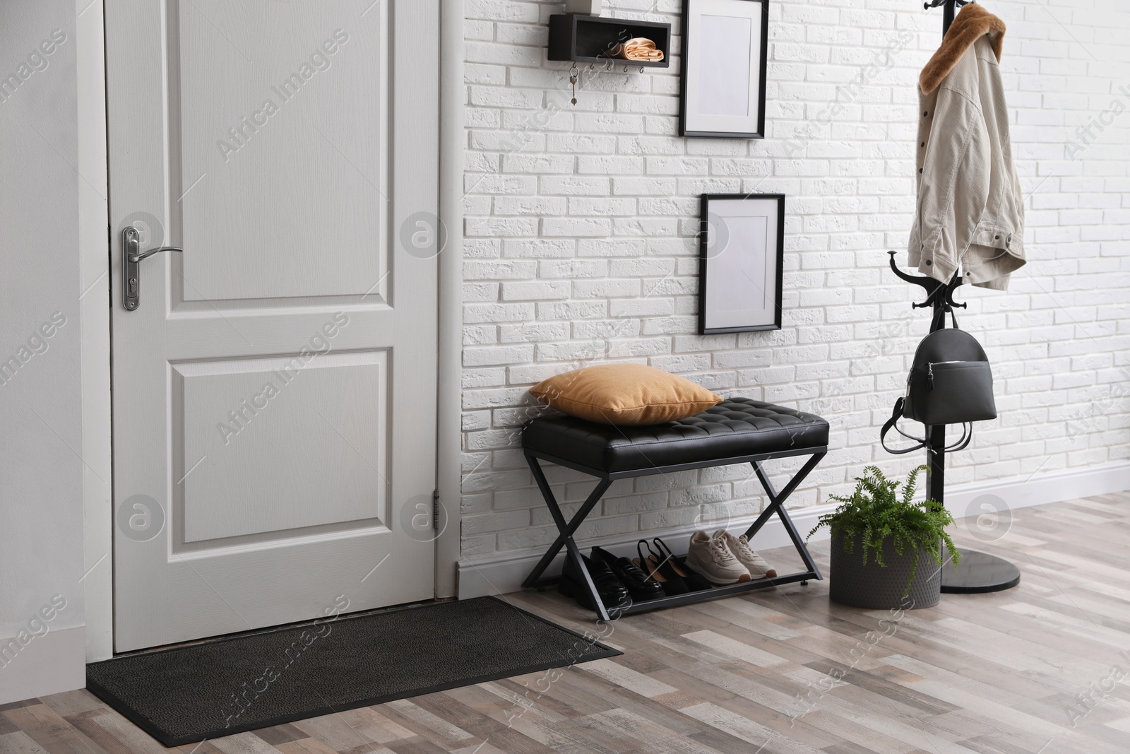 Photo of Stylish hallway interior with coat rack and bench