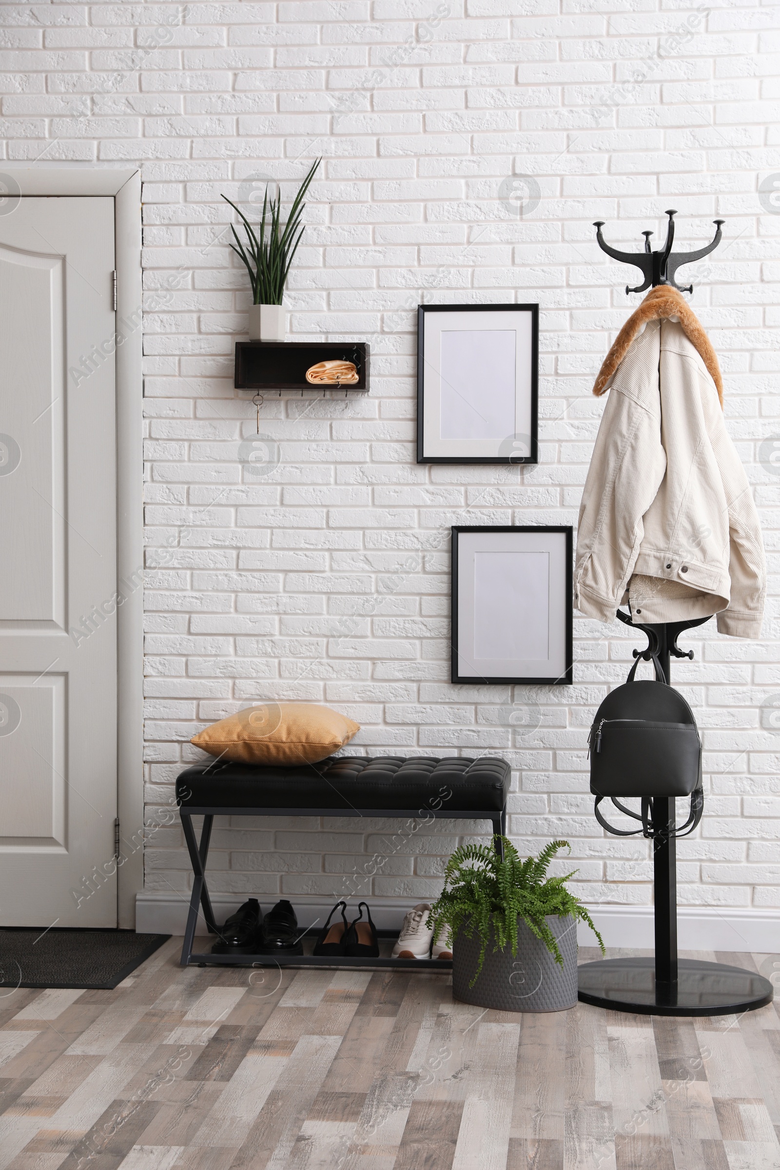 Photo of Stylish hallway interior with coat rack and bench