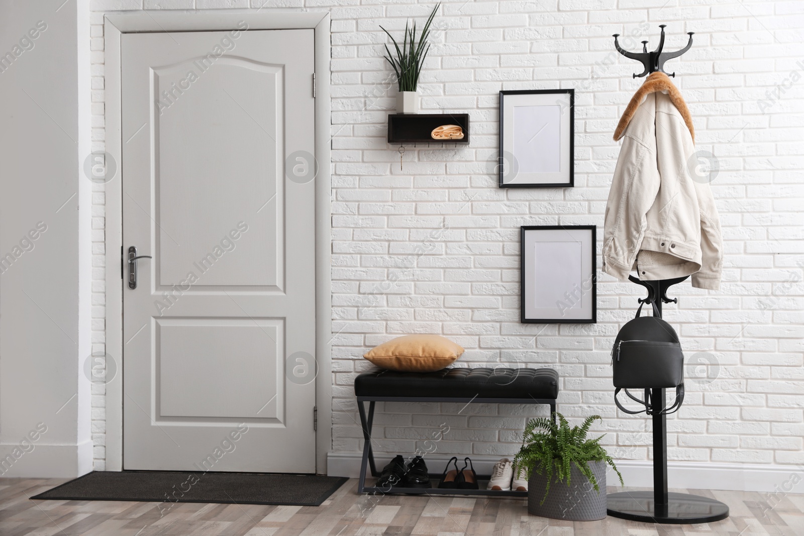 Photo of Stylish hallway interior with coat rack and bench