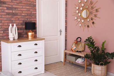 Photo of Stylish hallway interior with chest of drawers and bench