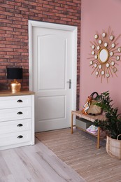 Photo of Stylish hallway interior with chest of drawers and bench