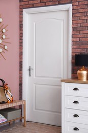 Photo of Stylish hallway interior with chest of drawers and bench