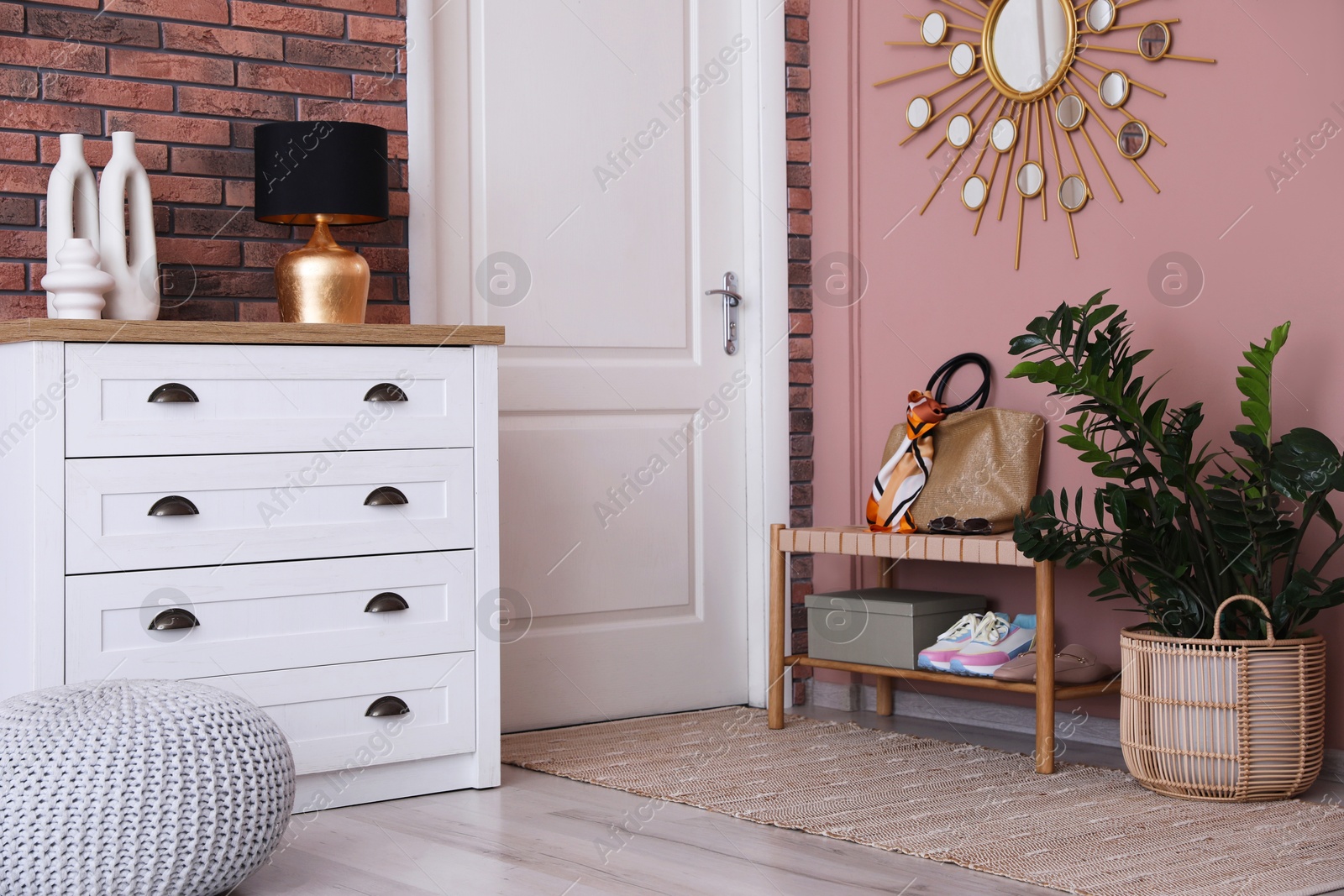 Photo of Stylish hallway interior with chest of drawers and bench