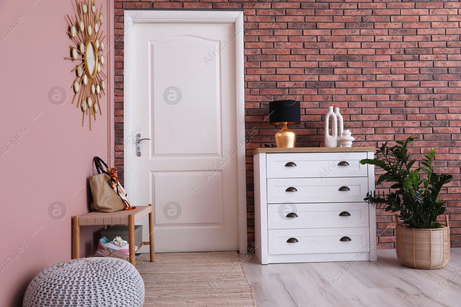 Photo of Stylish hallway interior with chest of drawers and bench