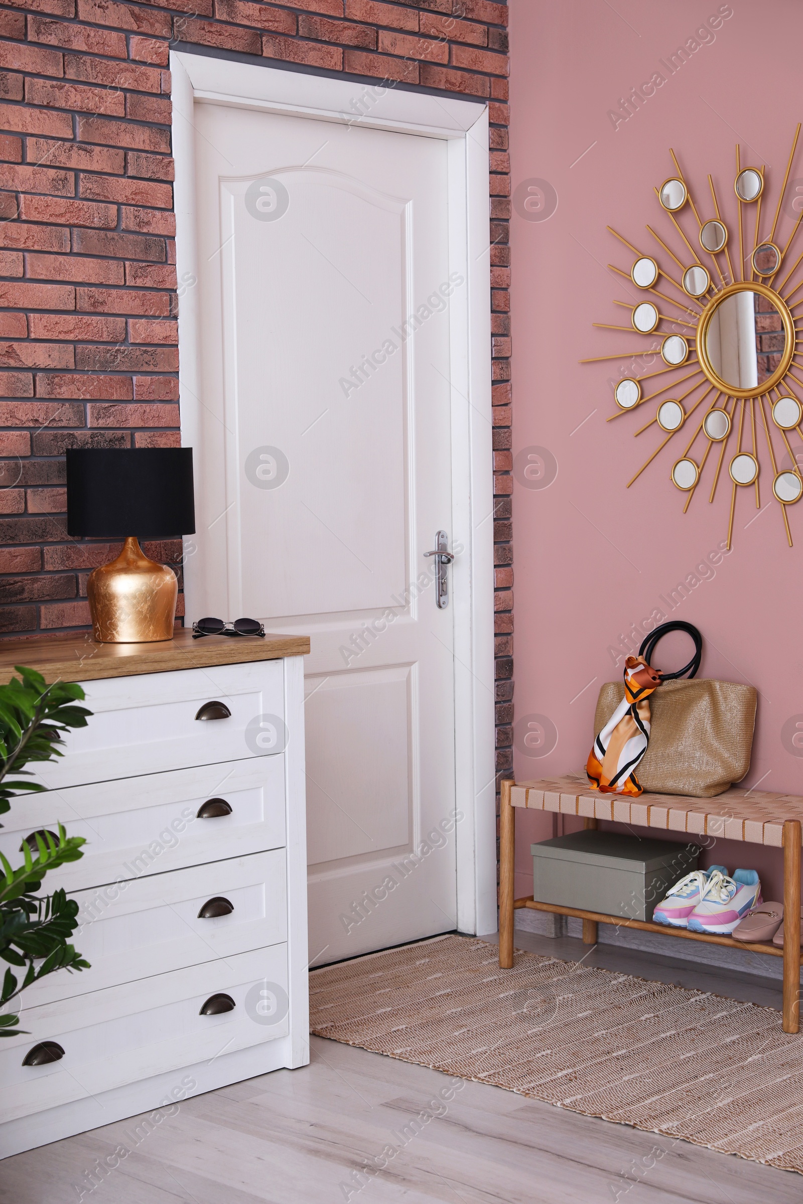 Photo of Stylish hallway interior with chest of drawers and bench