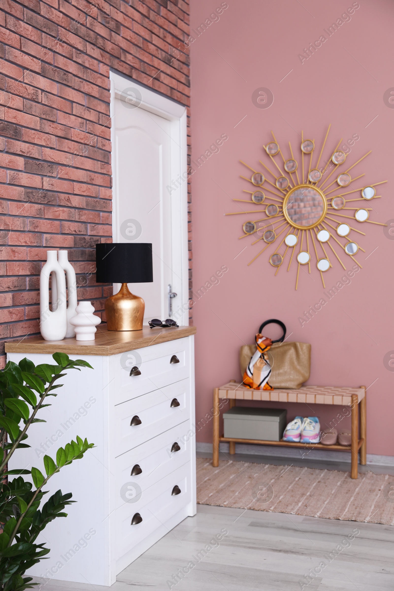 Photo of Stylish hallway interior with chest of drawers and bench