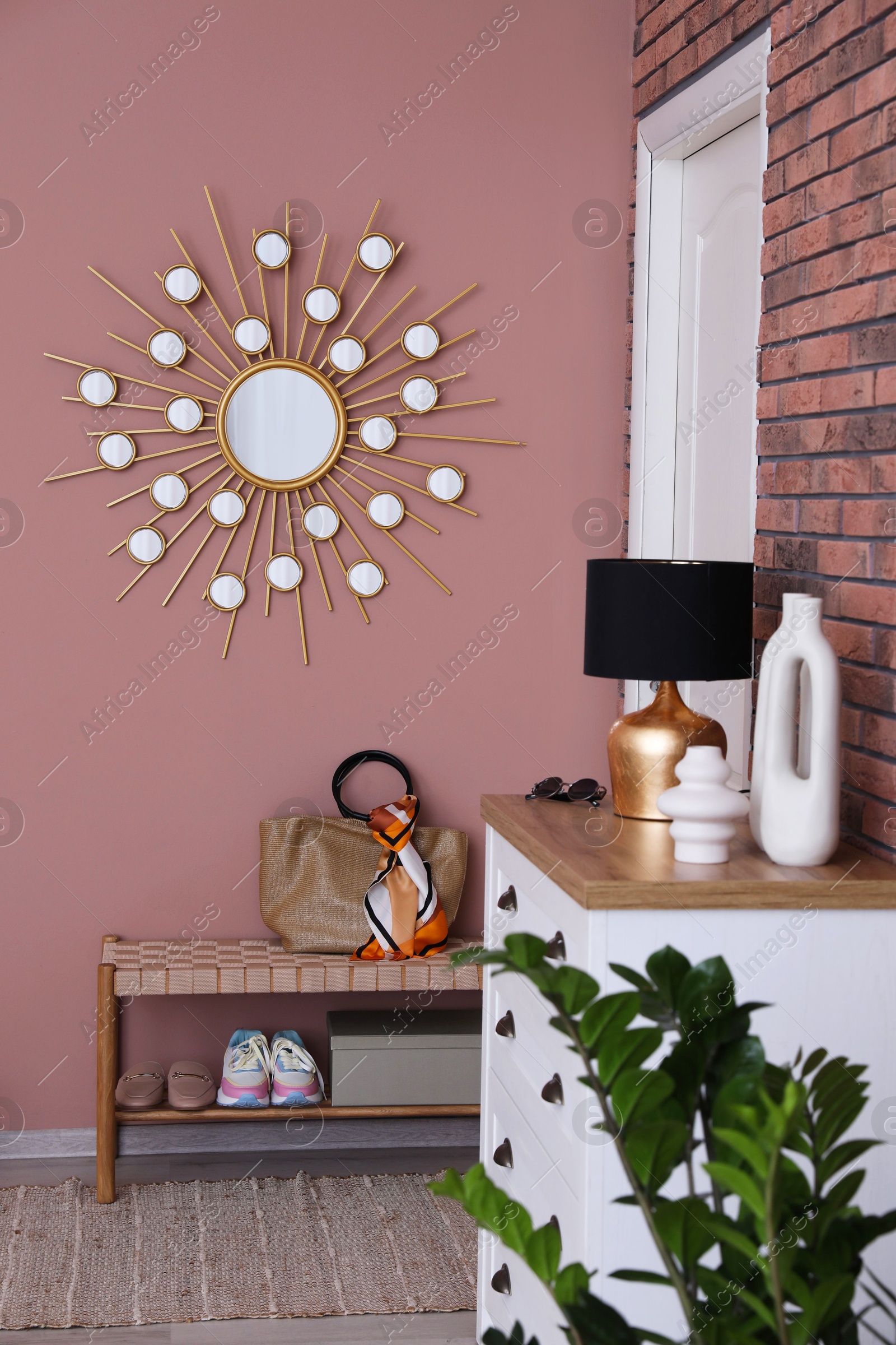 Photo of Stylish hallway interior with chest of drawers and bench