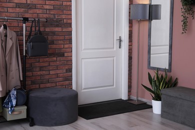 Photo of Stylish hallway interior with coat rack and mirror