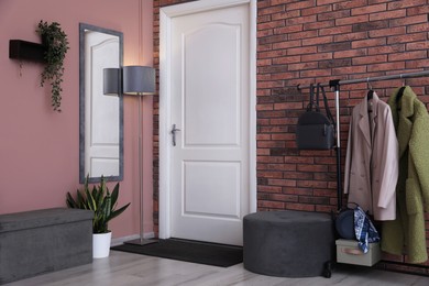 Photo of Stylish hallway interior with coat rack and mirror