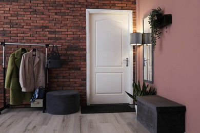 Photo of Stylish hallway interior with coat rack and mirror