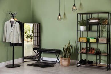 Photo of Stylish hallway interior with mirror and shelving unit