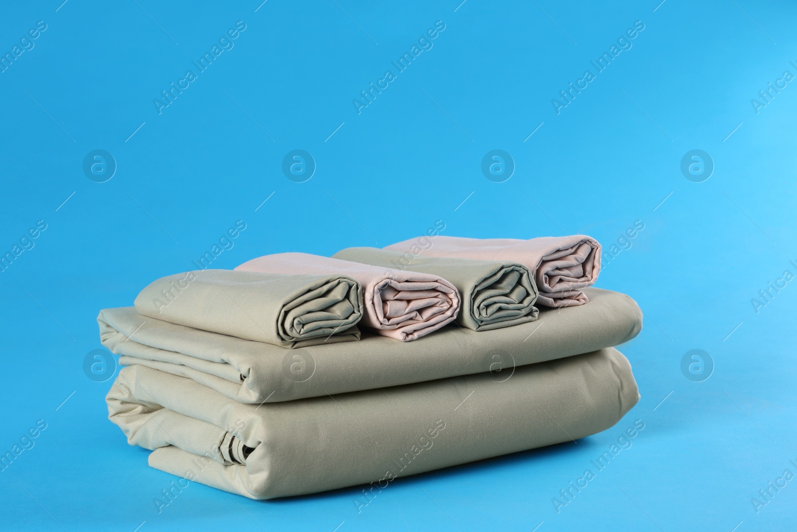 Photo of Stack of clean bed sheets on blue background