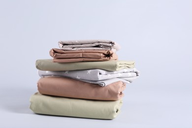 Stack of clean bed sheets on white background