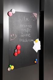 Magnetic board with shopping list and notes on refrigerator in kitchen