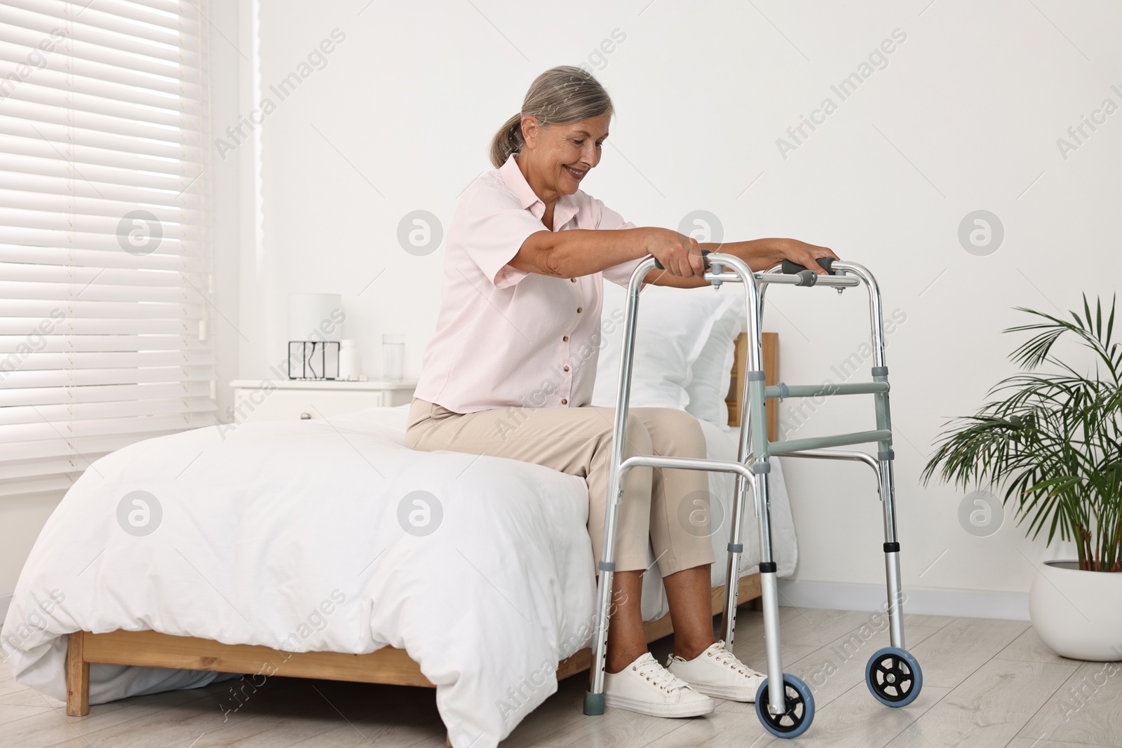 Photo of Senior woman with walking frame in hospital ward