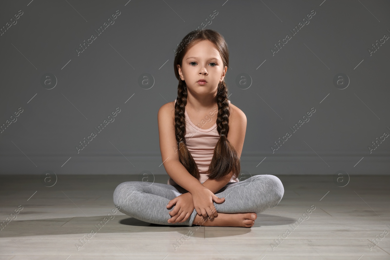 Photo of Orphanage concept. Sad girl sitting on floor indoors