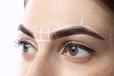 Young woman during henna eyebrows dyeing procedure on white background, closeup