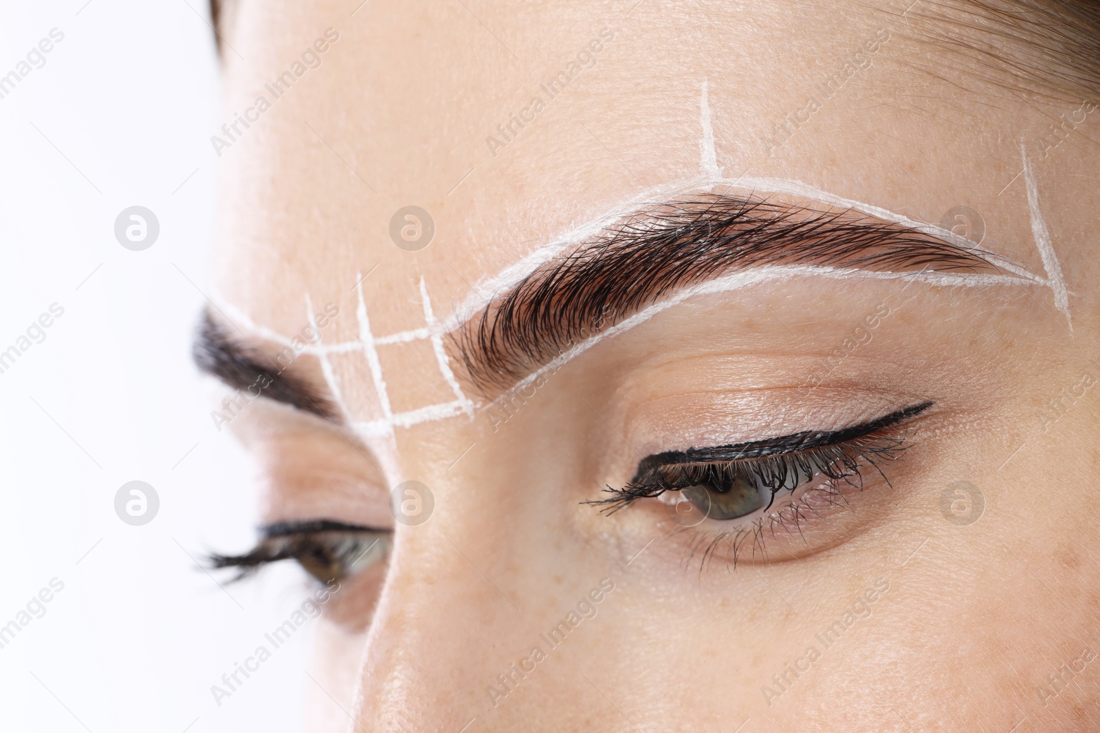 Photo of Young woman during henna eyebrows dyeing procedure on white background, closeup