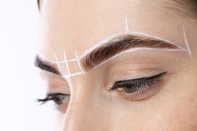 Young woman during henna eyebrows dyeing procedure on white background, closeup