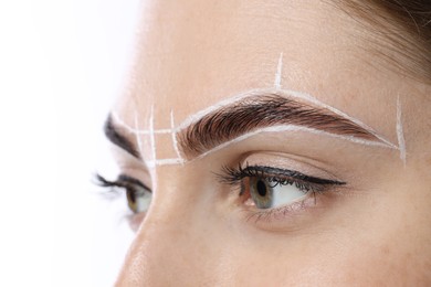 Young woman during henna eyebrows dyeing procedure on white background, closeup