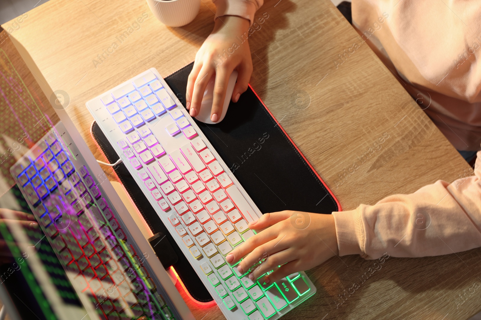 Photo of Girl using computer keyboard and mouse at wooden table indoors, above view