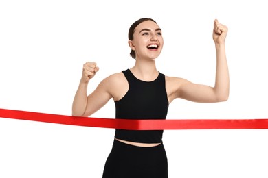 Beautiful woman in sportswear crossing red finish line on white background