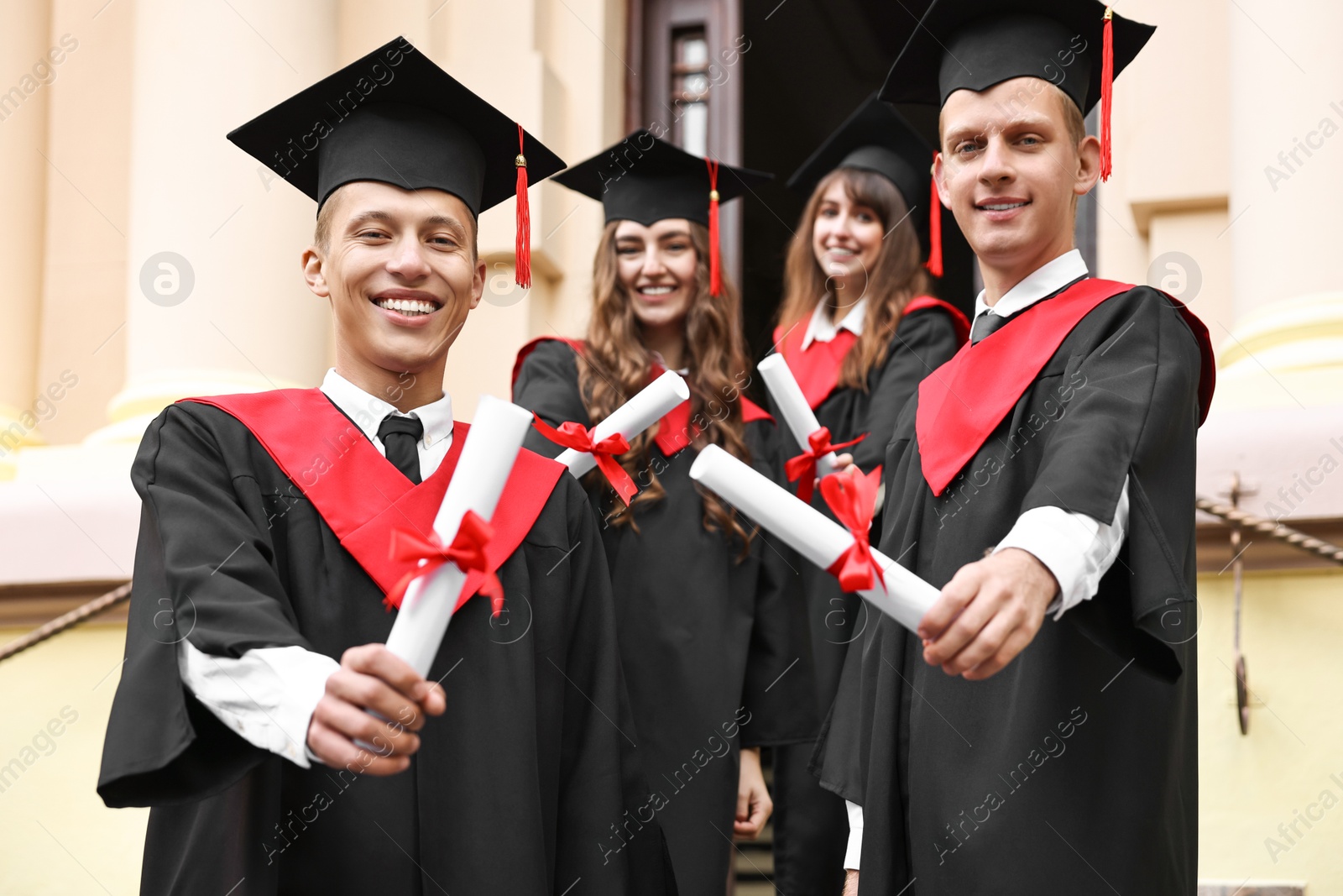 Photo of Graduation ceremony. Happy students with diplomas outdoors, selective focus