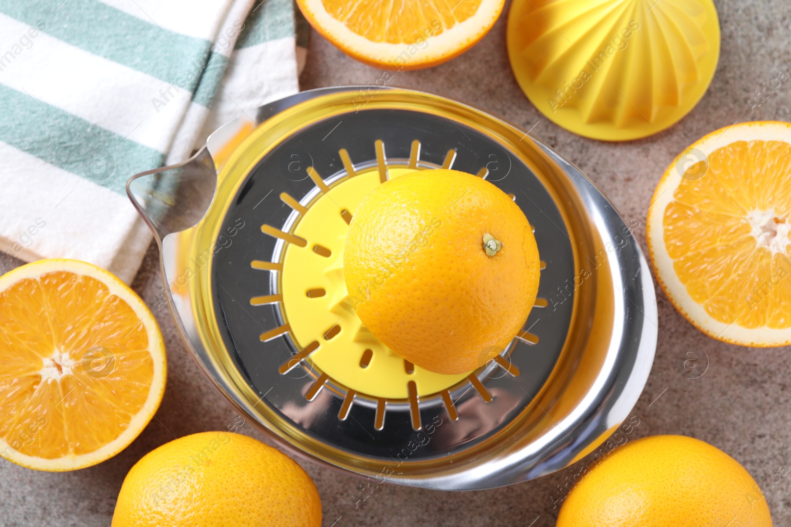 Photo of Metal juicer and oranges on grey table, top view