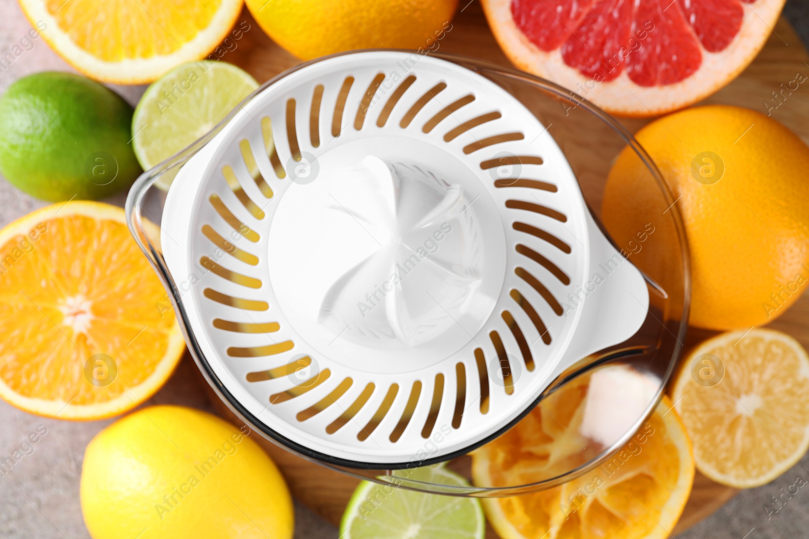 Photo of Plastic juicer and different citrus fruits on table, top view