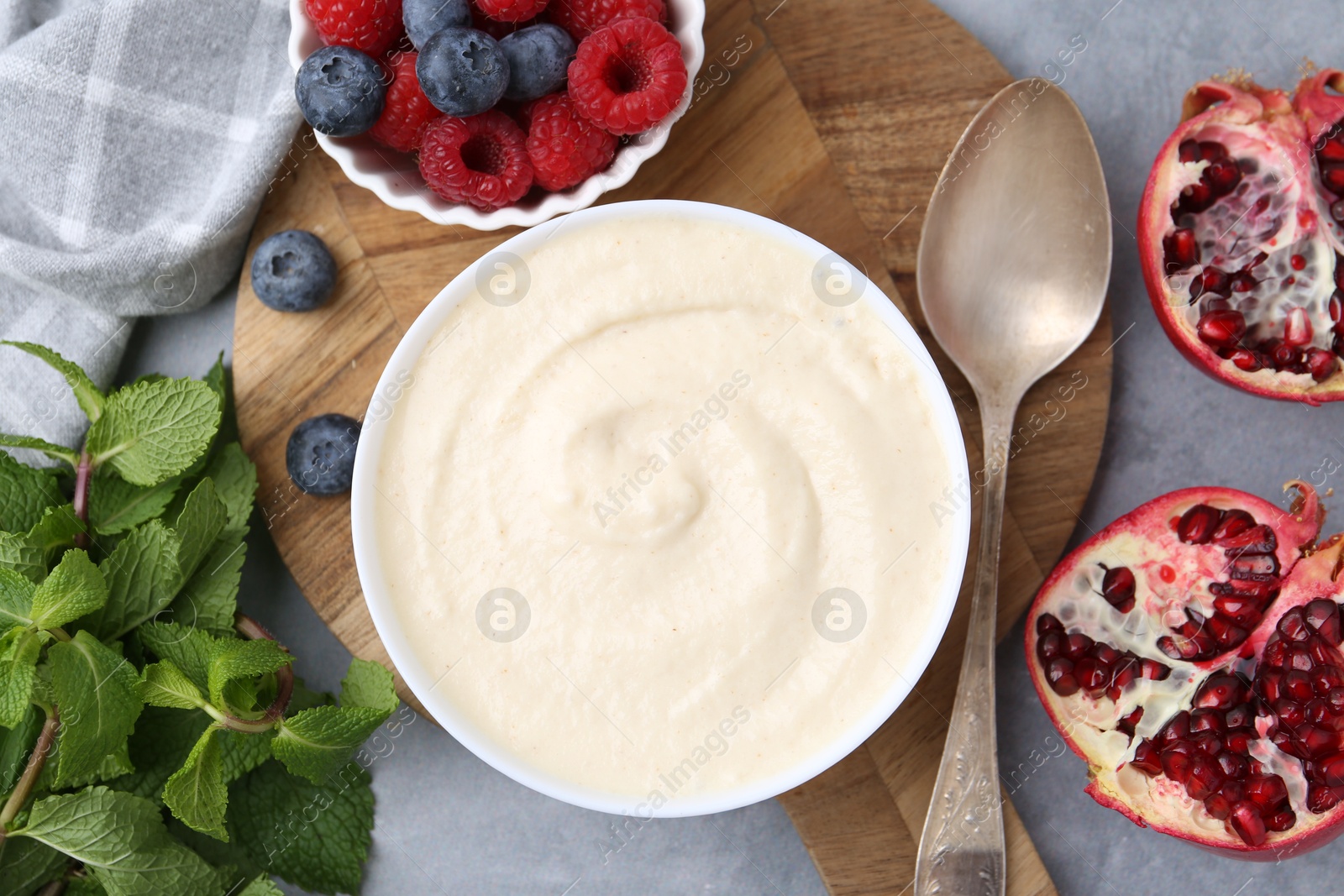 Photo of Tasty cooked semolina porridge served on grey table, top view