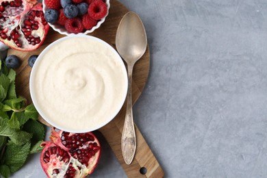 Photo of Tasty cooked semolina porridge served on grey table, top view. Space for text