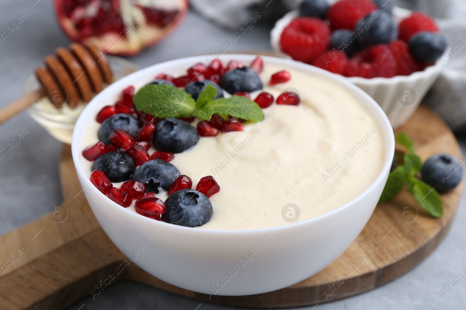 Photo of Tasty cooked semolina porridge served on grey table, closeup