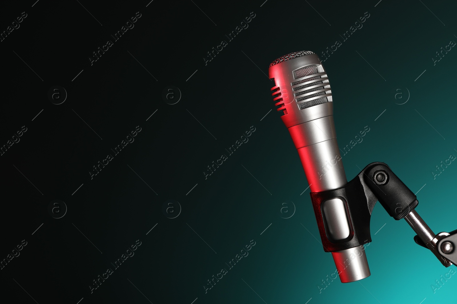 Photo of Stand with microphone on dark background, space for text. Sound recording and reinforcement