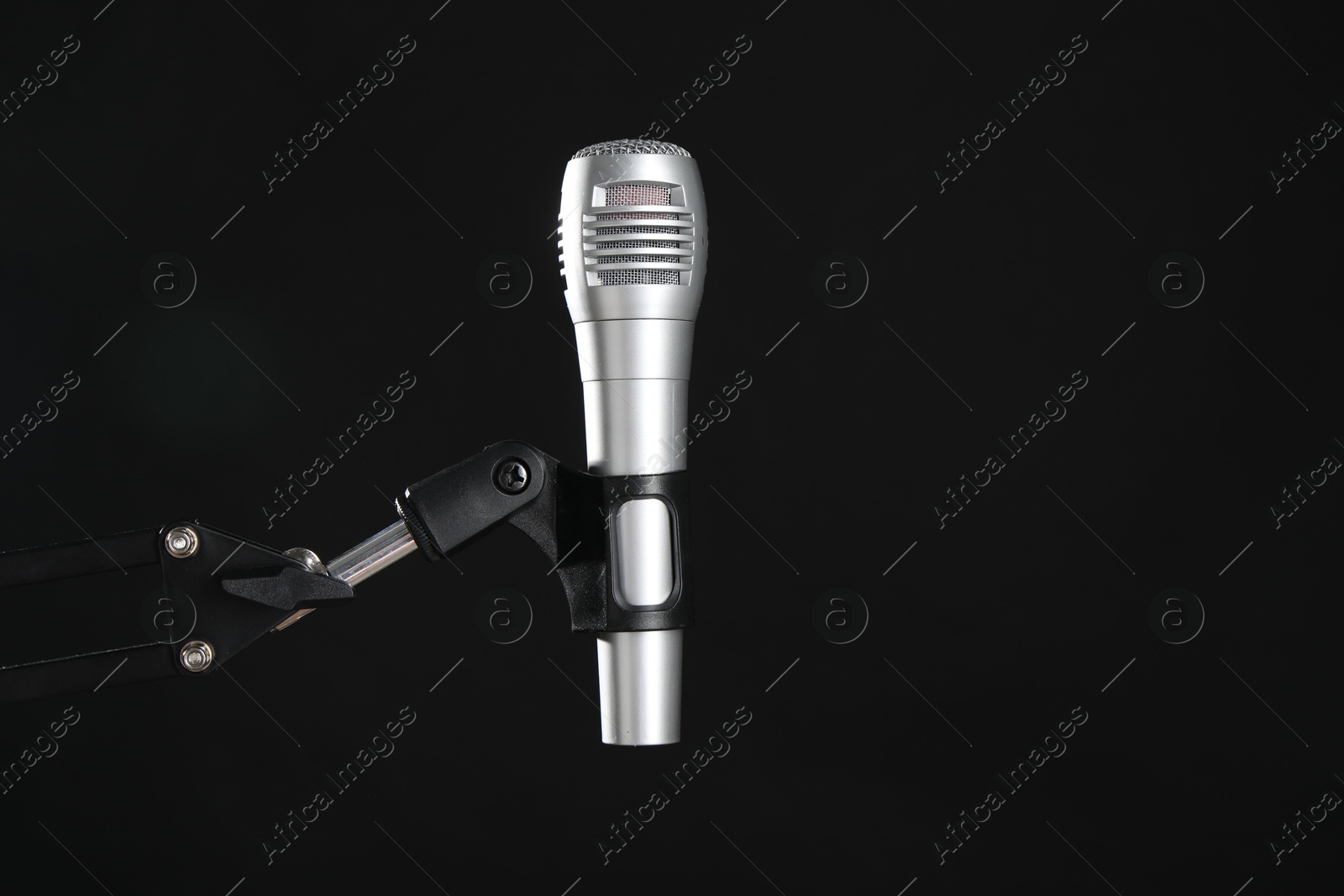 Photo of Stand with microphone on black background, space for text. Sound recording and reinforcement