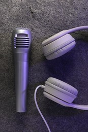 Photo of Microphone and headphones on grey textured background, flat lay. Sound recording and reinforcement