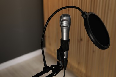 Photo of Stand with microphone and pop filter indoors. Sound recording and reinforcement