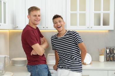 Happy brothers spending time together in kitchen