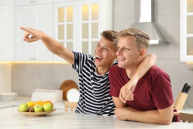 Happy brothers spending time together in kitchen