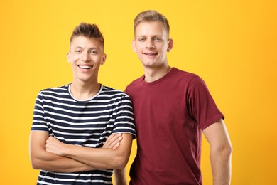 Photo of Portrait of happy brothers on orange background